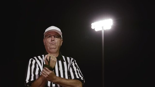 A football referee gives a holding penalty hand signal