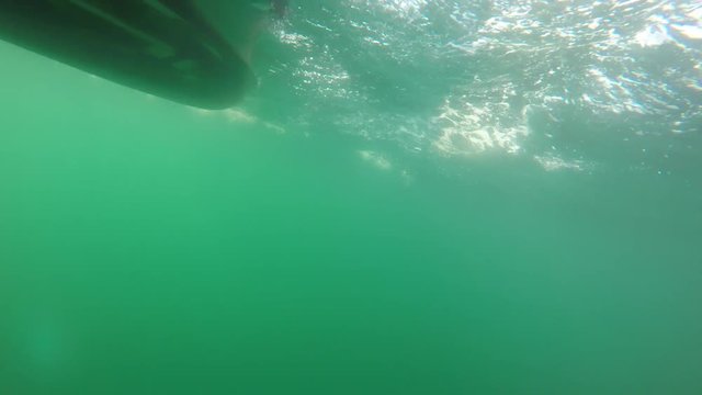 Underwater shot of small raft boat on rough ocean