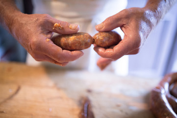 Unrecognizable man making sausages the traditional way at home.