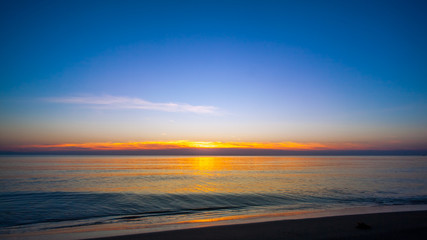 Fototapeta na wymiar Sunset on the beach with blue sky