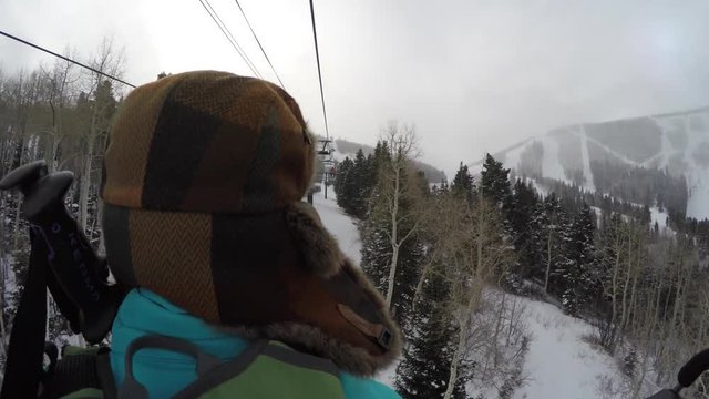 Woman riding on ski lift on cold day