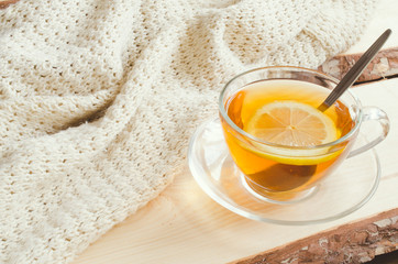 Cozy and soft winter background. Cup of tea and warm knitted sweater.