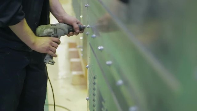 Man tightening a bolt or screw using a electric screwdriver. HD.