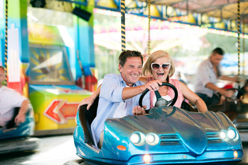 Senior couple in the bumper car at the fun fair
