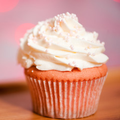 Tasty homemade cupcake with cream cheese on top close up. Selective focus.