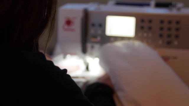 Woman uses sewing maching in her house on project