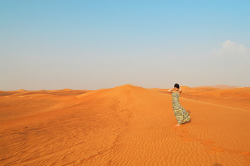 Fototapeta na wymiar silhouette of a girl in the setting sun in the desert in the Uni
