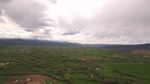An aerial panning shot of gorgeous green mountain valley in spring