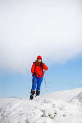 Fototapeta na wymiar Girl with backpack walking on snow in the mountains.