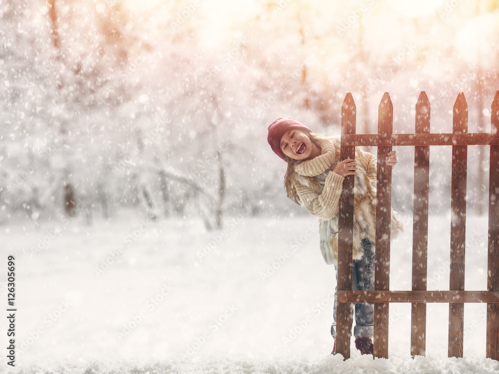 Wall mural girl playing on a winter walk