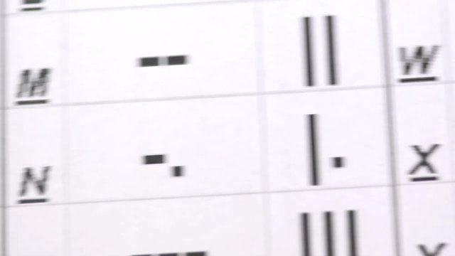 Footage of the Morse code symbols written on a paper, the shot is moving from right to left