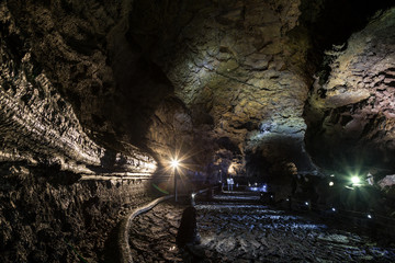 Inside the dark, lit and empty Manjanggul Lava Tube Cave on Jeju Island in South Korea. Manjanggul is one of the finest lava tunnels in the world and designated as an UNESCO World natural heritage.