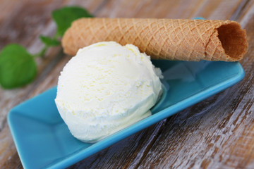 Scoop of delicious, creamy vanilla ice cream and crispy wafer, closeup
