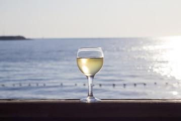 Glass of white wine on the background of the sea