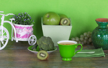 fruit juice, green fruits and vegetables on a wooden table