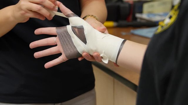 Nurse tapes a girls sprained wrist at hospital