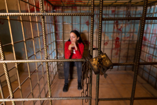 Female victim imprisoned in a metal cage with a blood splattered