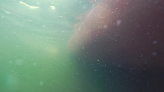 Underwater shot of bubbles passing by a boat hull while parking