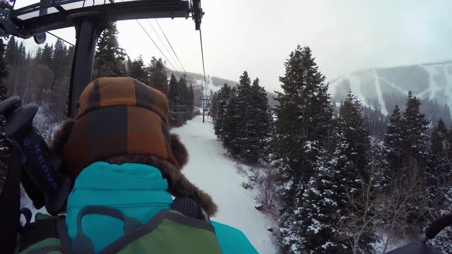 A woman riding on ski lift on cold day