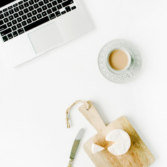 Flat lay modern feminine home office workspace. Laptop, coffee cup, cheese and knife on white background. Top view © Floral Deco