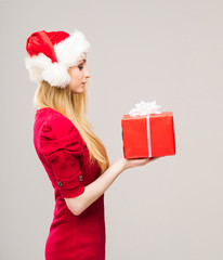 Young woman in a Christmas hat holding a present
