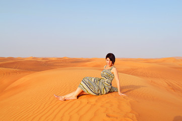 Fototapeta na wymiar silhouette of a girl in the setting sun in the desert in the Uni