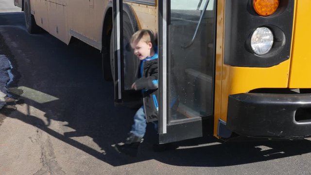 A little boy gets off the school bus