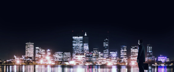 Obraz na płótnie Canvas Businessman viewing night glowing city