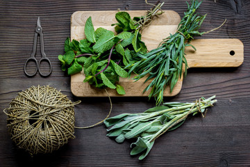 bundle of sage and thyme on wooden board top view