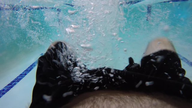 An underwater FPV shot of a man swimming back crawl