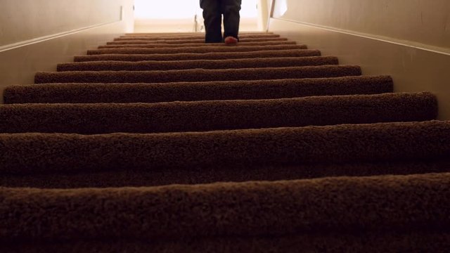 A boy walks down house basement stairs