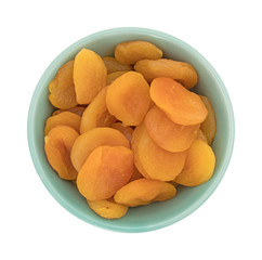 Dried apricots in a green bowl top view isolated on a white background.