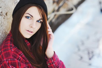 Portrait of a young successful beautiful long-haired girl brunettes with blue eyes on the street, closeup