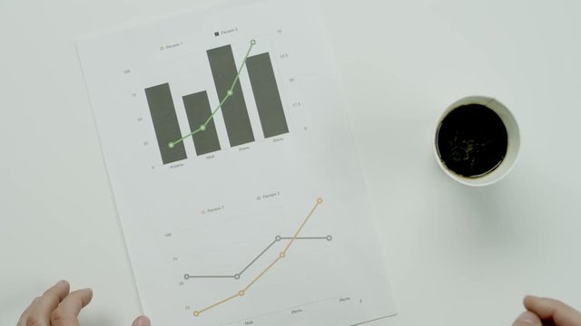 Male hands hold graphic charts.