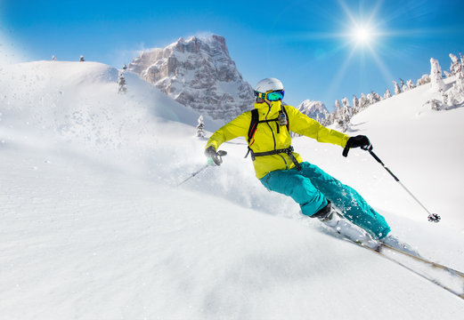 Skier skiing downhill in high mountains