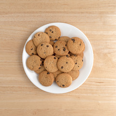 Vanilla chocolate chip crunchy cookies on a plate atop a wood table.
