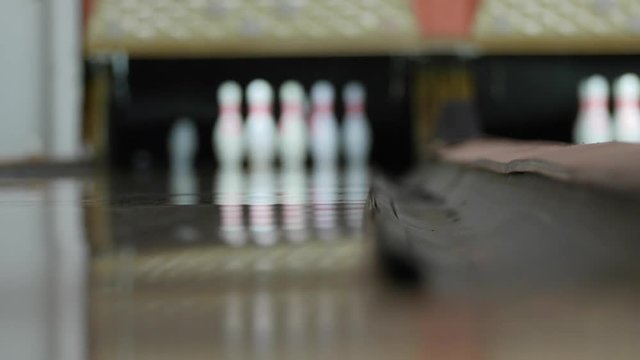 Bowling ball hits pins in bowling alley