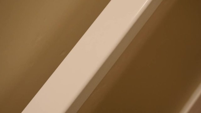 Gimbal shot of mans hand on railing going down stairs