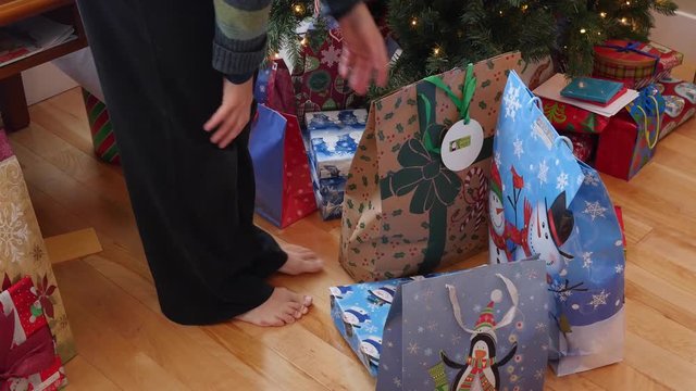 A family opens presents and stocking on Christmas morning in their home
