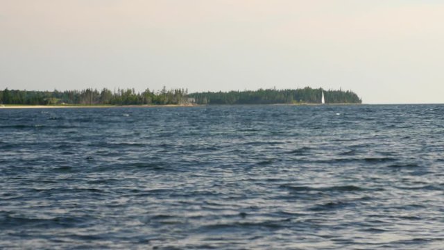 A sailboat floating by an island