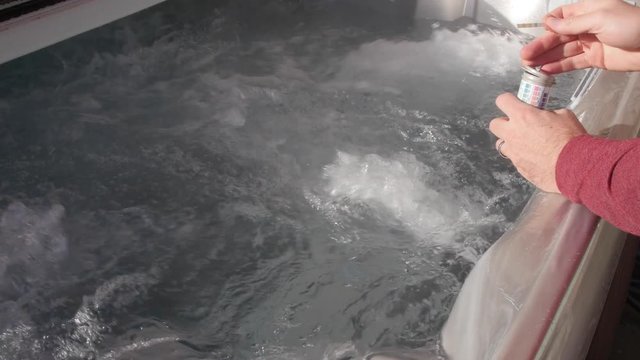 Man testing chemical levels in hot tub