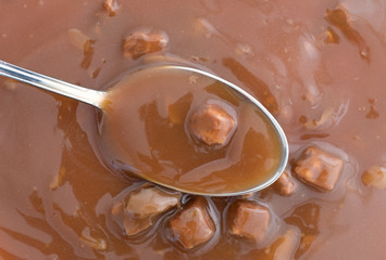 Mushroom soup with beef on a spoon.