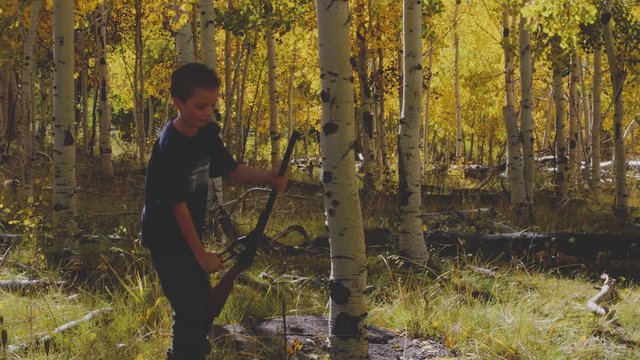 Boy shooting his bb gun while camping