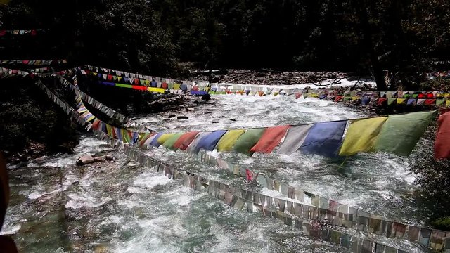 Bhutan river with prayer flags from a bridge