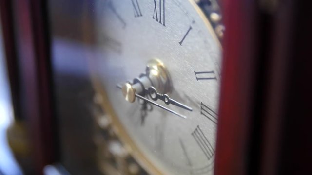 An antique clocks hands turn with time