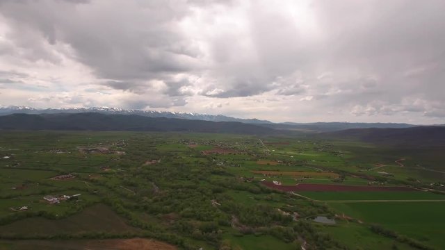 Aerial panning shot of gorgeous green mountain valley in spring