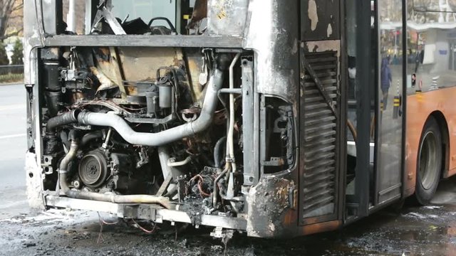 Burnt public traffic bus is seen on the street after caught in fire during travel and extinguished by firefighters.