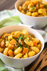Hörnchennudeln mit Hackfleisch- und Kürbissauce bestreut mit Petersilie, fotografiert mit natürlichem Licht (Selektiver Fokus, Fokus in die Mitte des Gerichts)