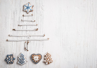 Christmas tree made of branches and gingerbread cookie as background