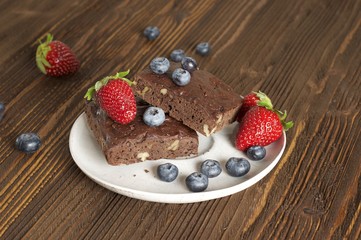 Chocolate - cherry brownie served with blueberry and strawberry 